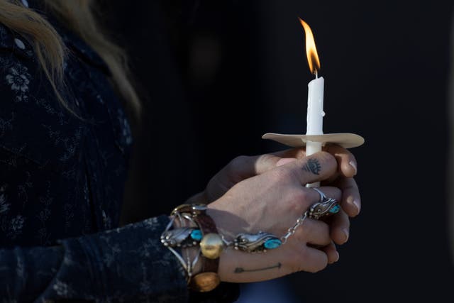 <p>A woman holding a candle at a vigil for victims of the school shooting in Nashville, Tennessee </p>