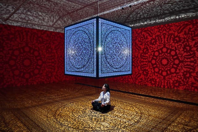 <p>A visitor admires the title piece, a large suspended steel cube casting shadow patterns across the walls, by Anila Quayyum Agha at a preview for All The Flowers Are For Me show at Shirley Sherwood Gallery of Botanical Art in Kew Gardens. </p>
