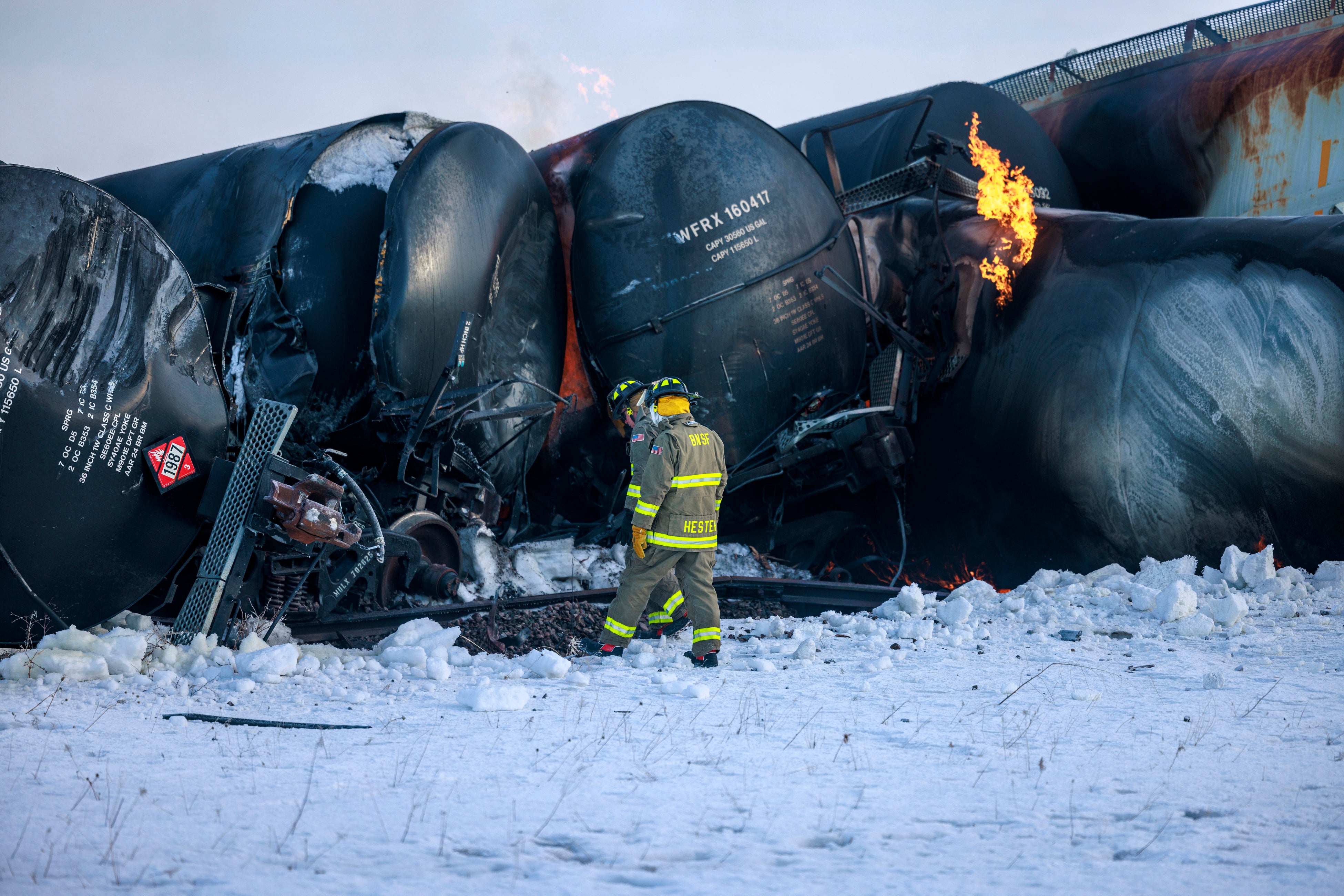 Firefighters work near piled-up train cars, near Raymond, Minnesota on Thursday, March 30, 2023, the morning after a BNSF freight train derailed