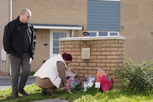 A couple lays flowers at the scene in Meridian Close, Bluntisham, Cambridgeshire. (Joe Giddens/ PA)