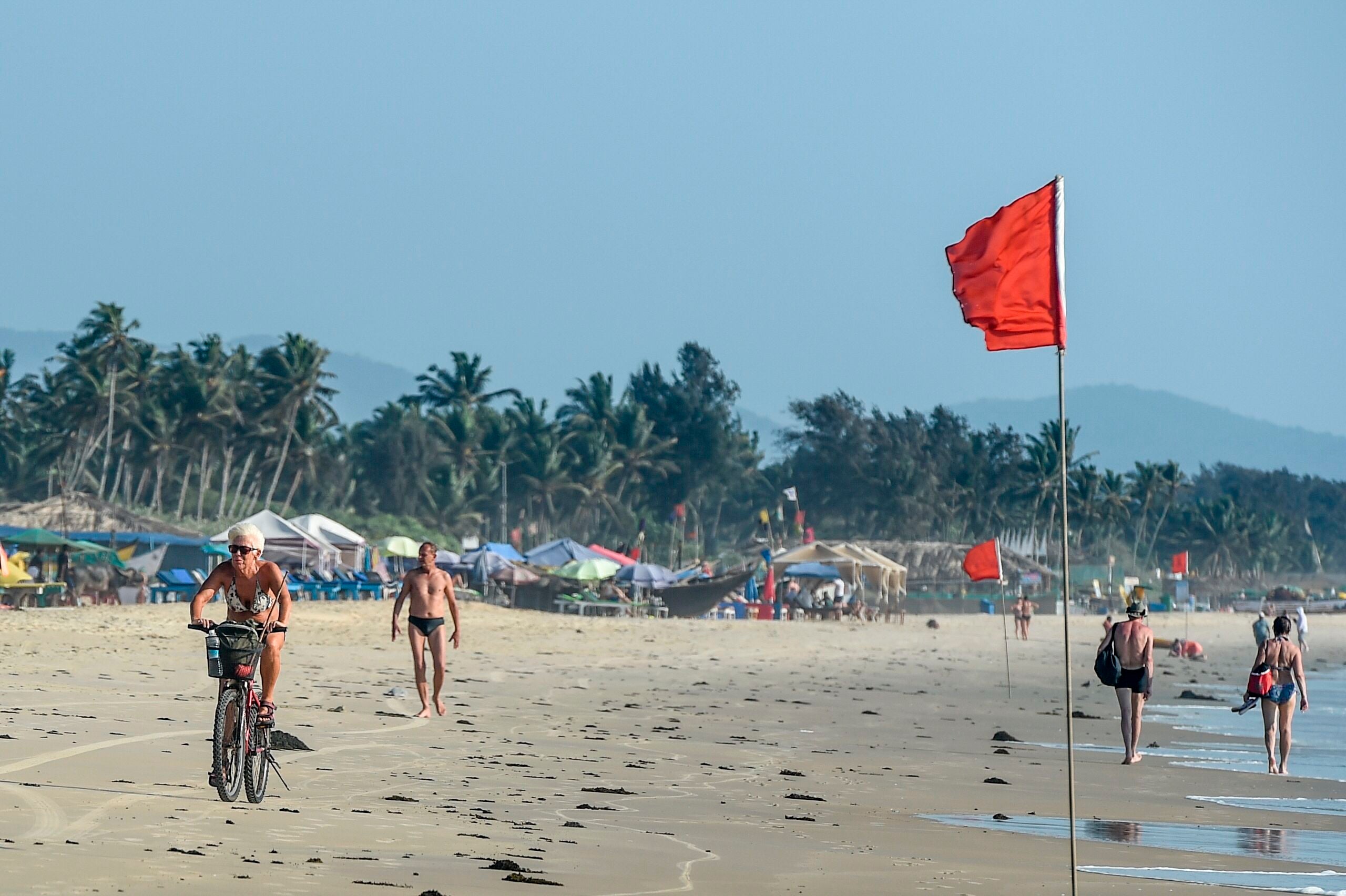File: Foreigners enjoy walking and riding bikes on the beach in Goa on 13 March 2020