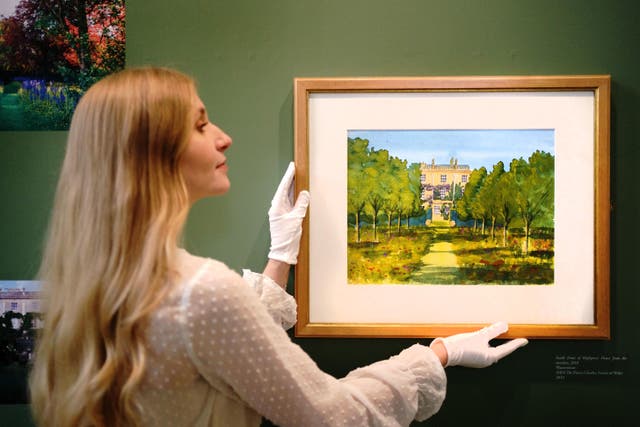 Exhibition curator Rosie Alderton of The Prince’s Foundation adjusts a watercolour painted by King Charles III in 2010 depicting his country home Highgrove House, ahead of the Prince’s Foundation exhibition at the Garrison Chapel, Chelsea Barracks, London. Picture date: Friday March 31, 2023.