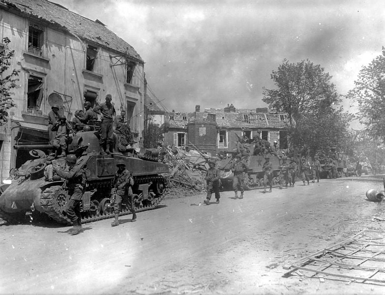 <p>American armoured and infantry forces pass through the Normandy town of Coutances during Operation Cobra</p>