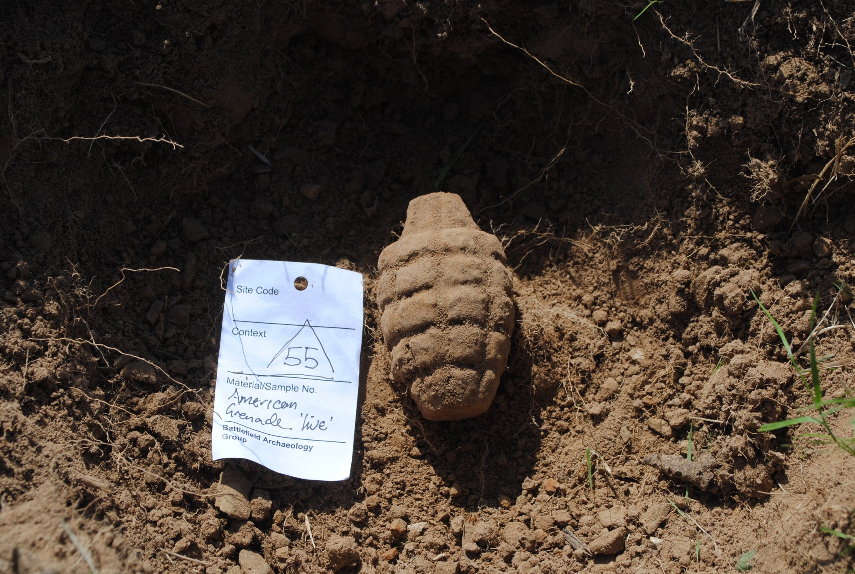 <p>An unexploded American hand grenade, excavated by the archaeologists immediately adjacent to a German dugout</p>