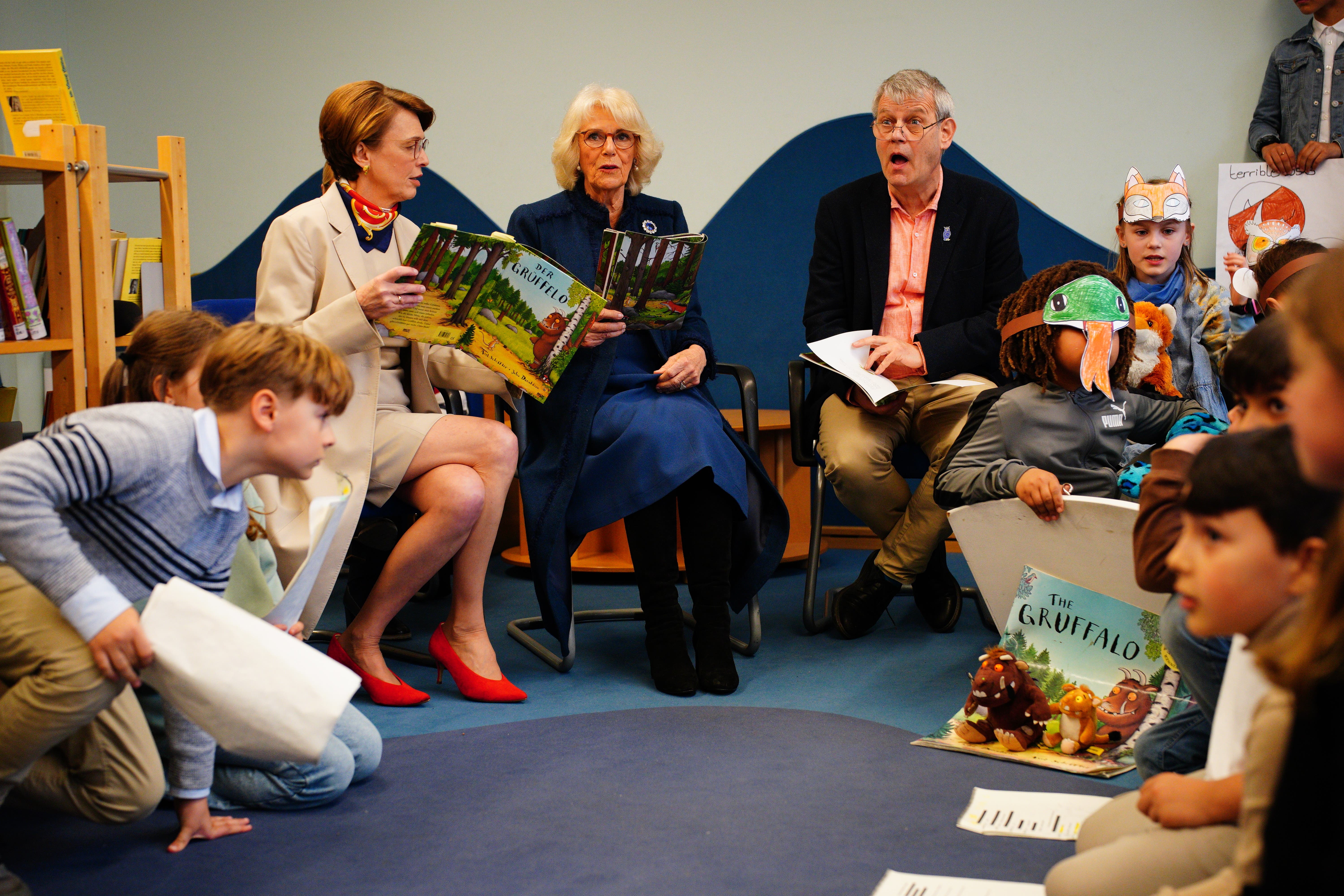 The Queen Consort reading The Gruffalo with Axel Scheffler, right, the illustrator of the children’s book during a visit to Rudolf Ross Grundschule School, Hamburg, to hear about the immersive language learning methods the school offers to its students (Ben Birchall/PA)