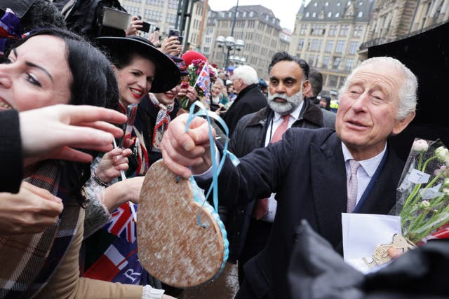 The King receives gifts as he meets members of the public during a visit to Hamburg City Hall (Chris Jackson/PA)