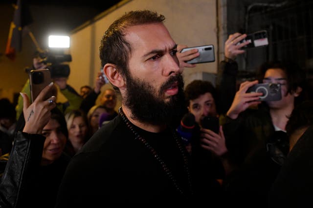 <p>Young fans and media surround Andrew Tate as he leaves a police detention facility in Bucharest, Romania</p>