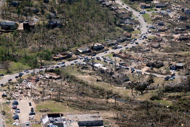 <p>Cars line up along the road as cleanup continues from Friday's tornado damage in west Little Rock, Arkansas </p>