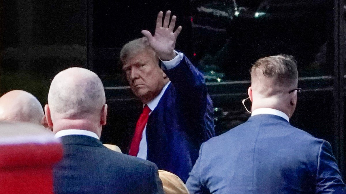 Donald Trump waves to crowd as he arrives at Trump Tower before arraignment