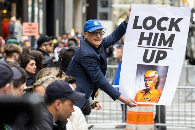 <p>A protester holds a placard outside Trump Tower in New York on Monday, April 3, 2023. Former President Donald Trump is expected to be booked and arraigned on Tuesday on charges arising from hush money payments during his 2016 campaign. (AP Photo/Corey Sipkin)</p>