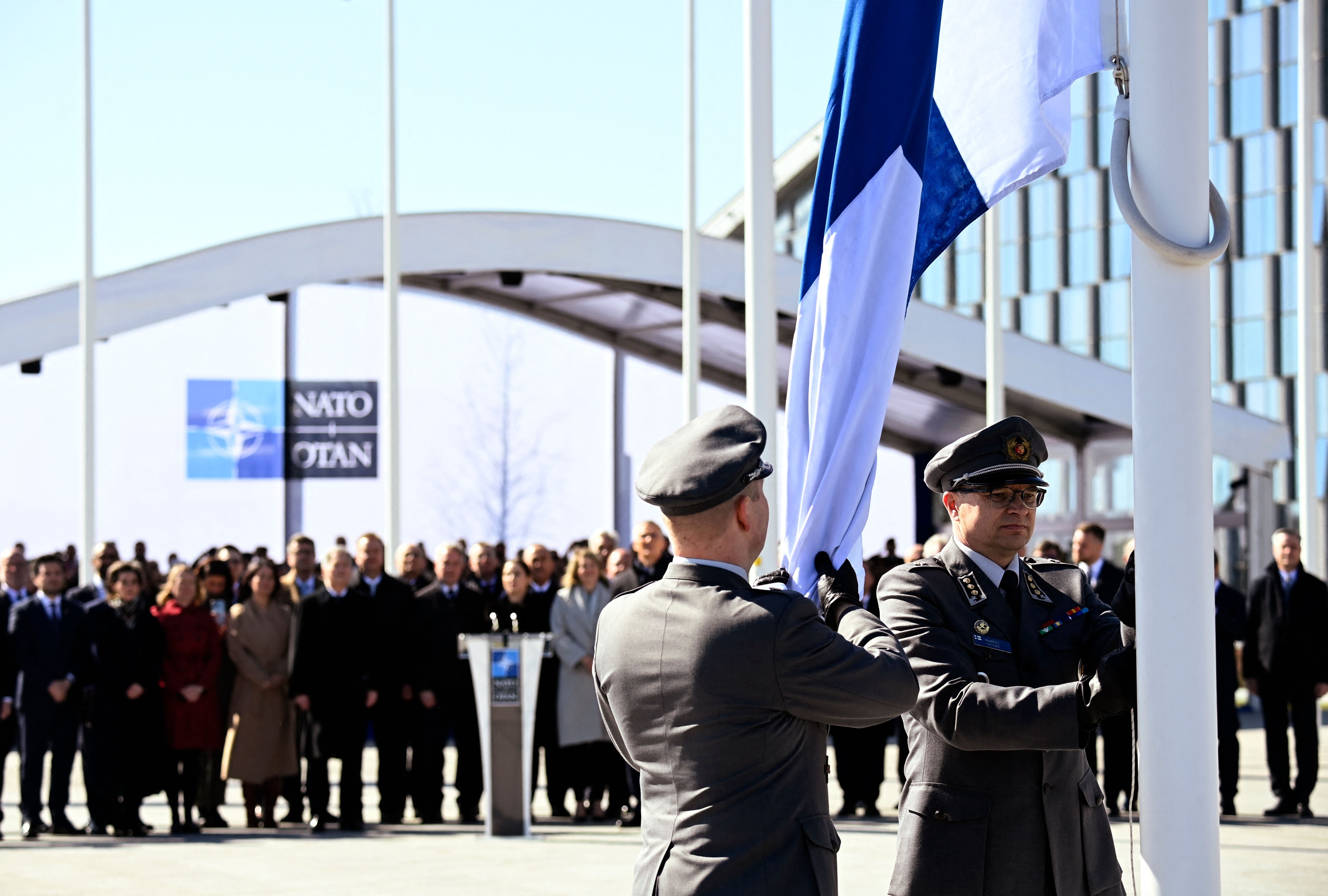 Finnish military personnel install the Finnish national flag at Nato HQ in Brussels