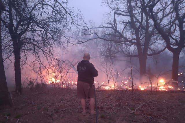 <p>Jim Garinger, fights a fire outside his home built by his great-grandfather, March 31, 2023, in Guthrie, Oklahoma. Garinger and his family were able to save his family home with the help of firefighters. Extremely dry conditions in Oklahoma combined with high winds to fuel several large wildfires that forced interstate closures and sent residents fleeing from their homes (Jessica Garinger via AP)</p>