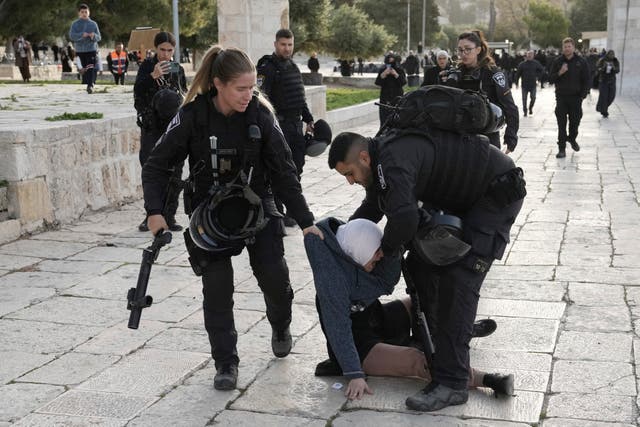 <p>Israeli police arrest a Palestinian woman at the Al-Aqsa Mosque compound following a raid at the site in the Old City of Jerusalem</p>