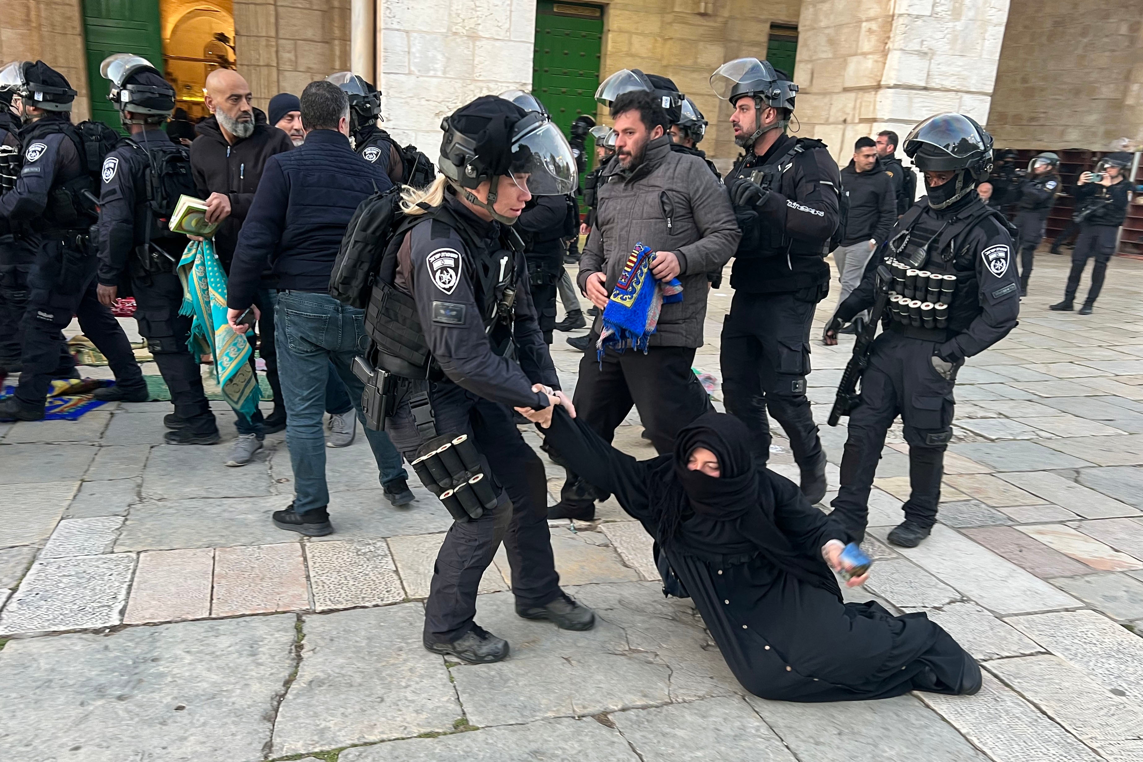 Israeli security forces remove Palestinian Muslim worshippers sitting on the grounds of the Al-Aqsa mosque compound in Jerusalem