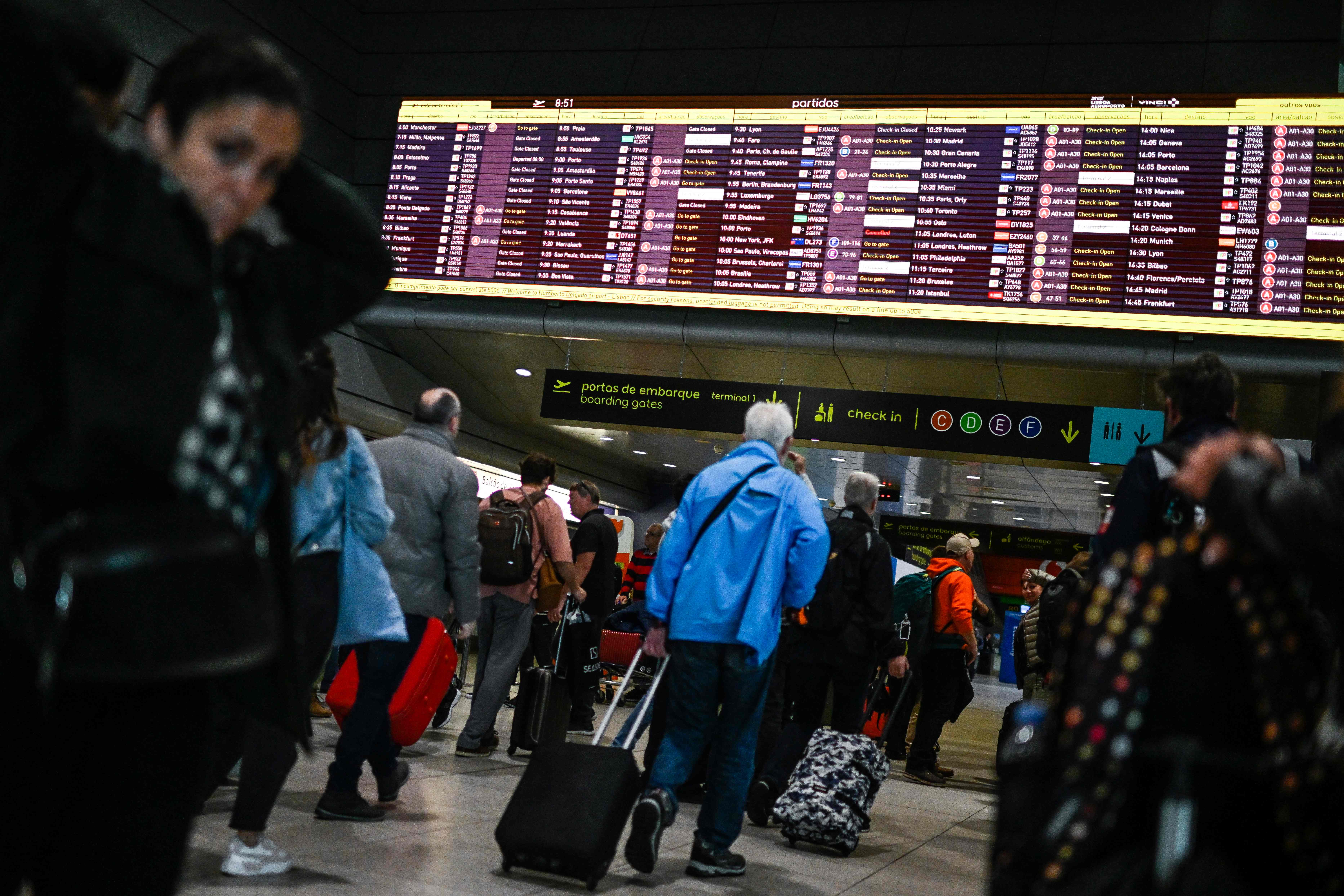 Passengers look at the departures board at Humberto Delgado airport in Lisbon on April 1, 2023