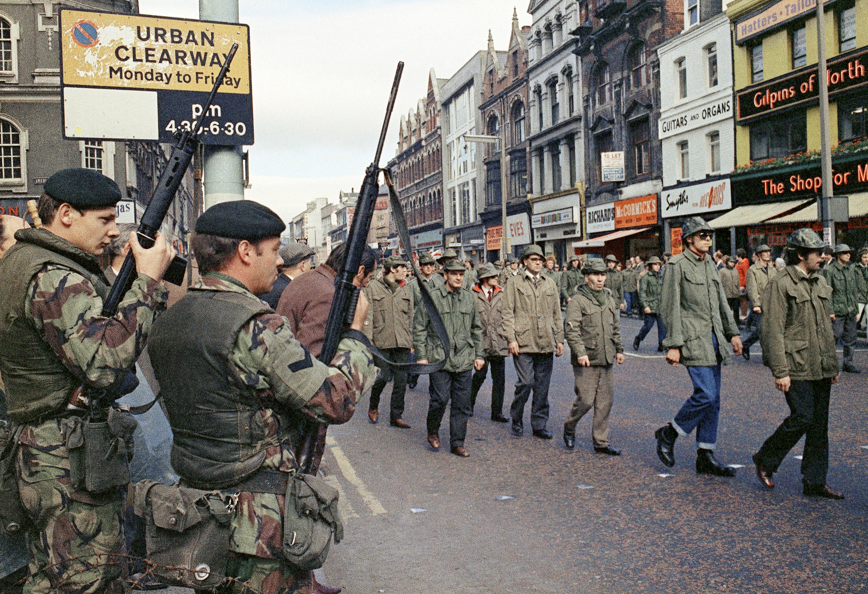British troops watch as members of the Ulster Defence Association parade through Belfast