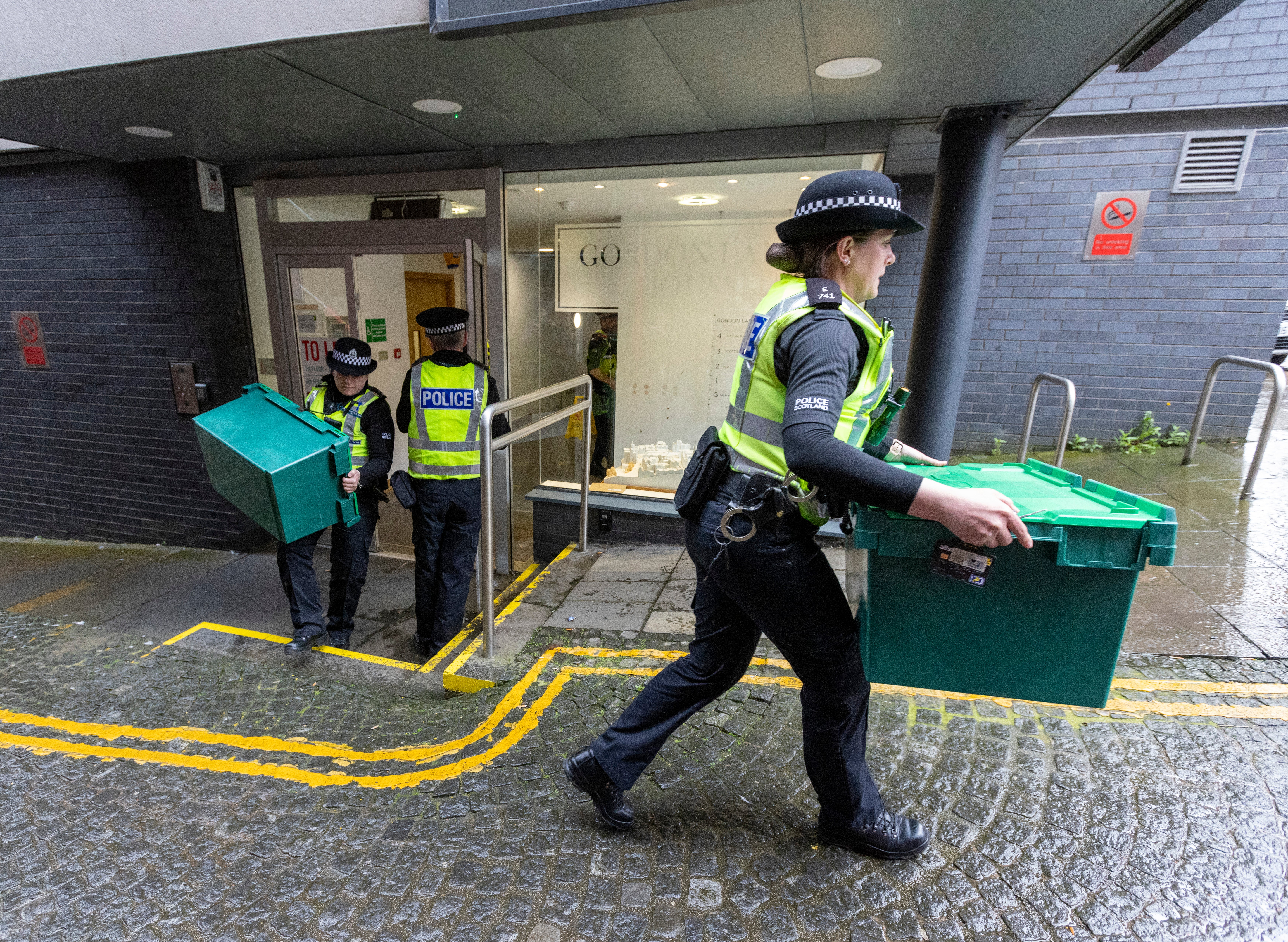 Police officers carry boxes out of the Scottish National Party offices in Edinburgh yesterday