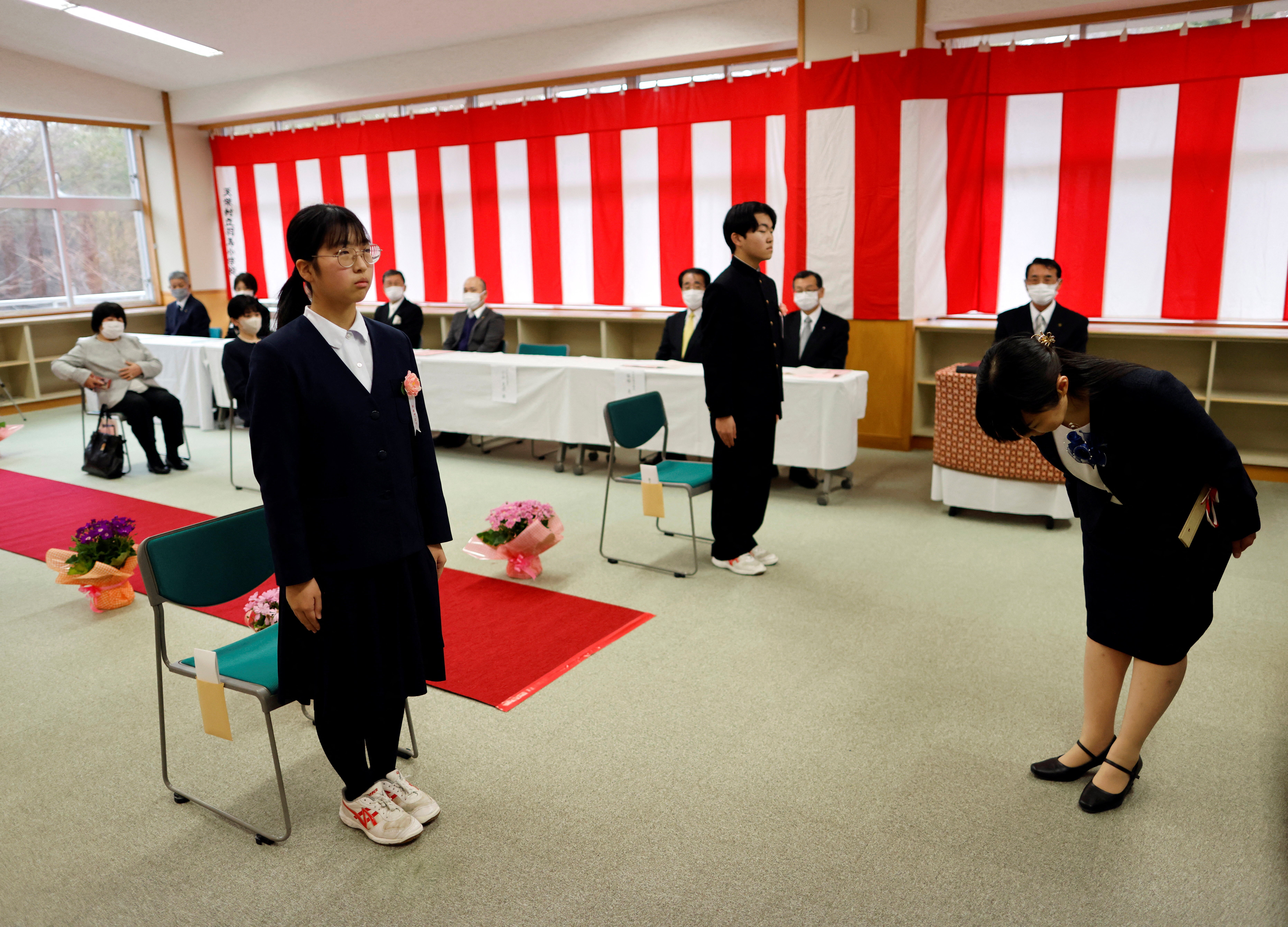 Eita Sato, 15, and Aoi Hoshi, 15, the only two students at Yumoto Junior High School, attend their graduation ceremony, in Ten-ei Village, Fukushima prefecture