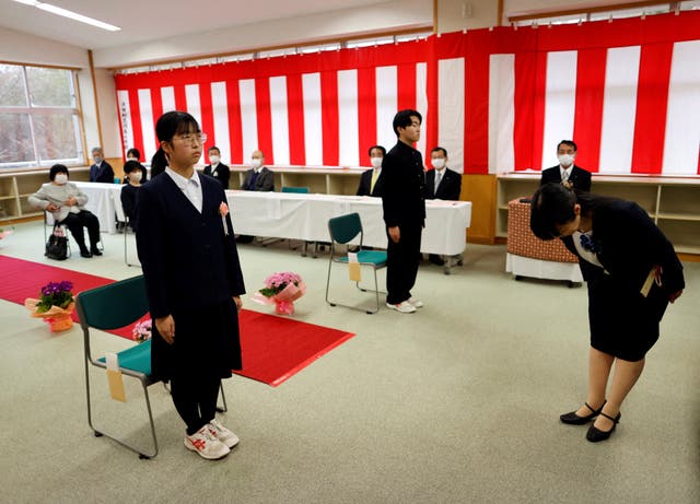 <p>Eita Sato, 15, and Aoi Hoshi, 15, the only two students at Yumoto Junior High School, attend their graduation ceremony, in Ten-ei Village, Fukushima prefecture</p>