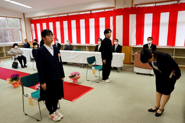 <p>Eita Sato, 15, and Aoi Hoshi, 15, the only two students at Yumoto Junior High School, attend their graduation ceremony, in Ten-ei Village, Fukushima prefecture</p>