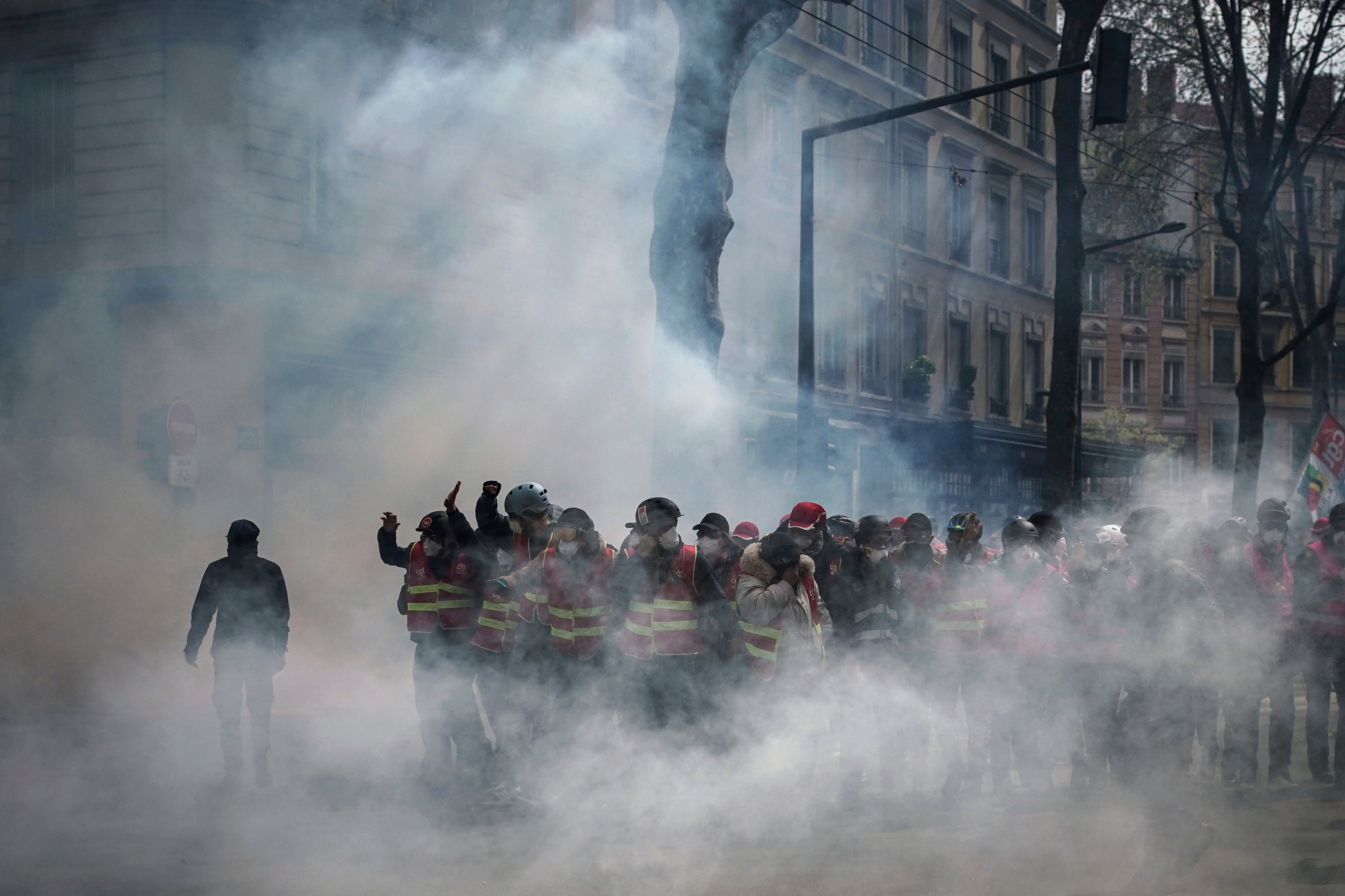 Union members stand in tear gas in Lyon on Thursday