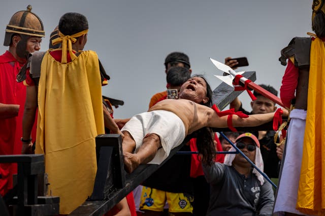 <p>Penitent Ruben Enaje grimaces in pain as he is nailed to a cross during Good Friday crucifixions in San Fernando, Pampanga, Philippines</p>