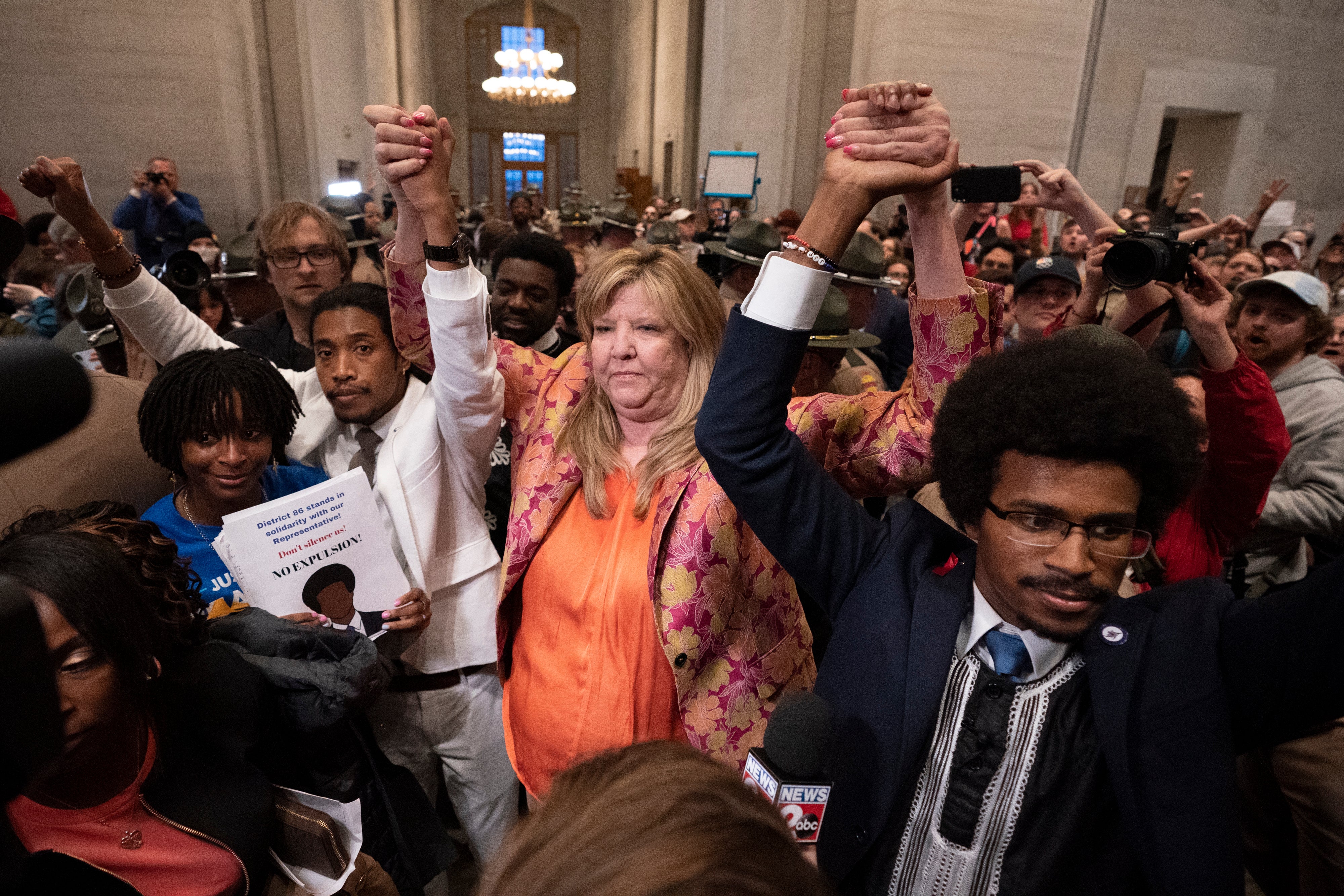 Former Rep Justin Jones, Rep Gloria Johnson and former Rep Justin Pearson raise their hands outside the House chamber after Jones and Pearson were expelled from the legislature