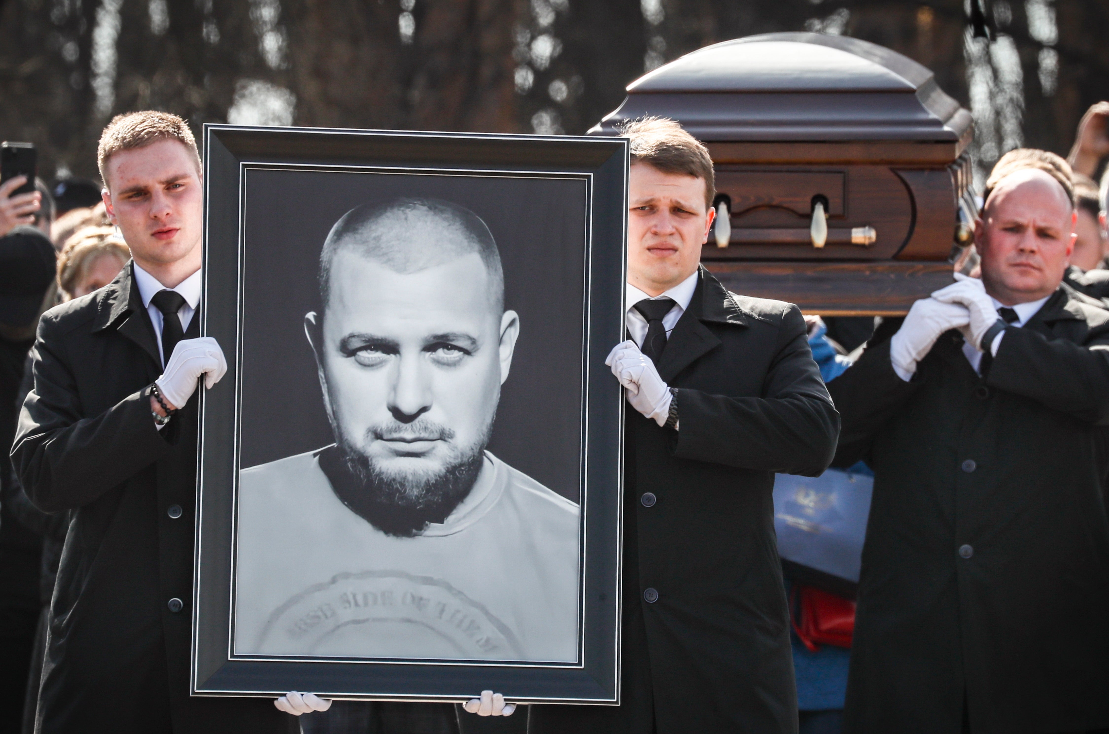Pallbearers carry a picture and the coffin with the body of Tatarsky, at the Troekurovsky cemetery in Moscow last year