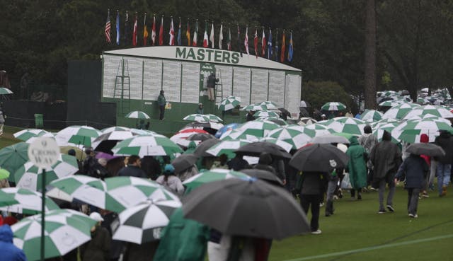 <p>Patrons make their way past the leaderboard following the suspension of play in the third round of the Masters Tournament</p>