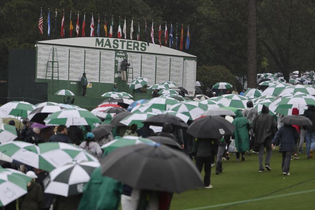<p>Patrons make their way past the leaderboard following the suspension of play in the third round of the Masters Tournament</p>