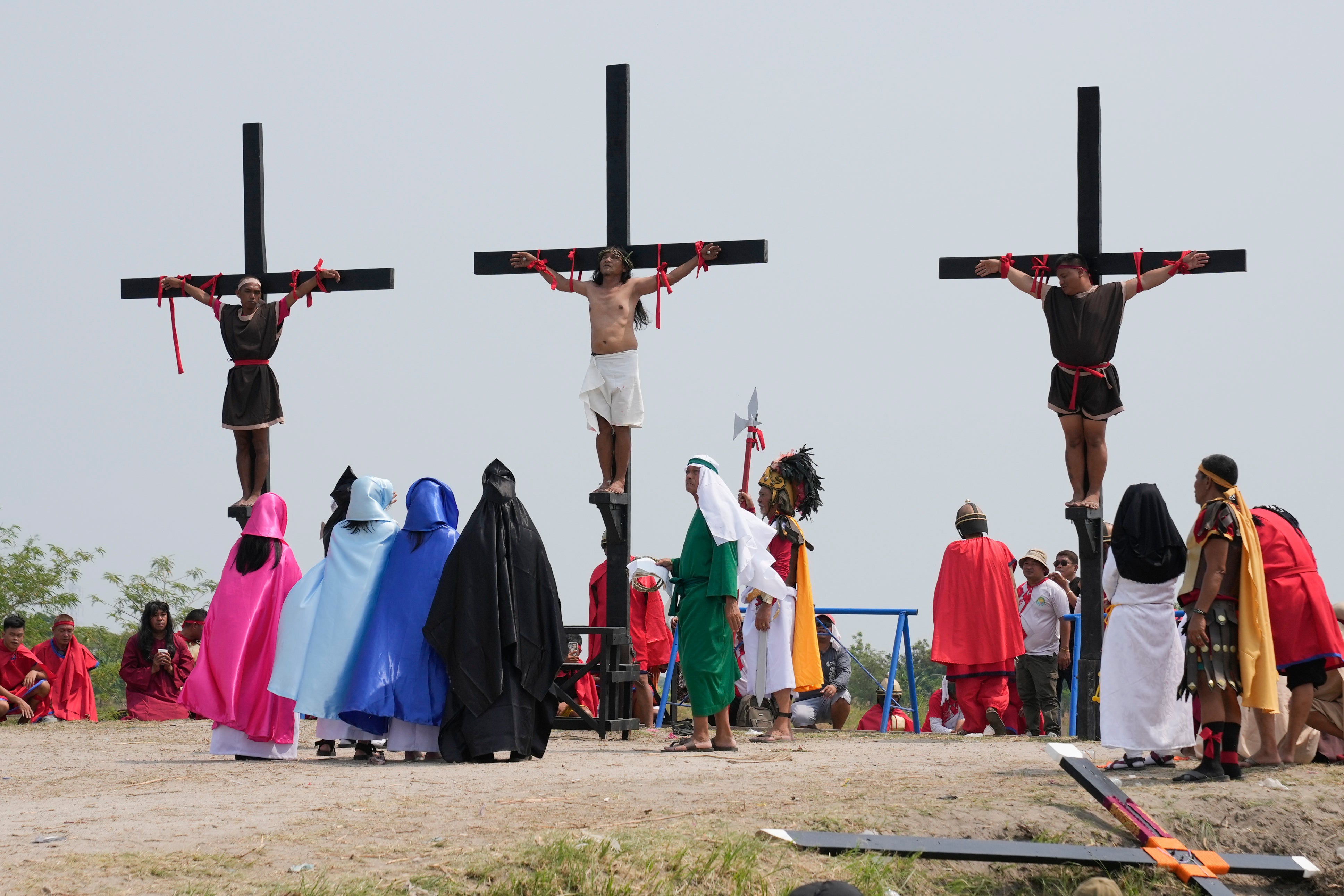 Ruben Enaje, centre, stays on the cross beside two other devotees during a reenactment of Jesus Christ’s sufferings as part of Good Friday rituals