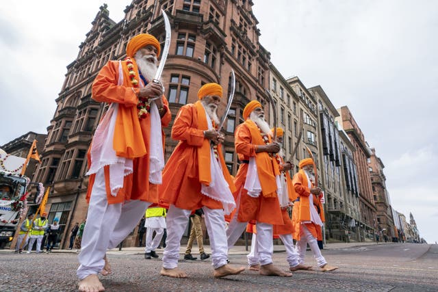 People walk along Hope Street as they take part in the annual procession in Glasgow as part of the Sikh Vaisakhi celebration to celebrate the Birth of the Sikh Nation. (Jane Barlow/PA)