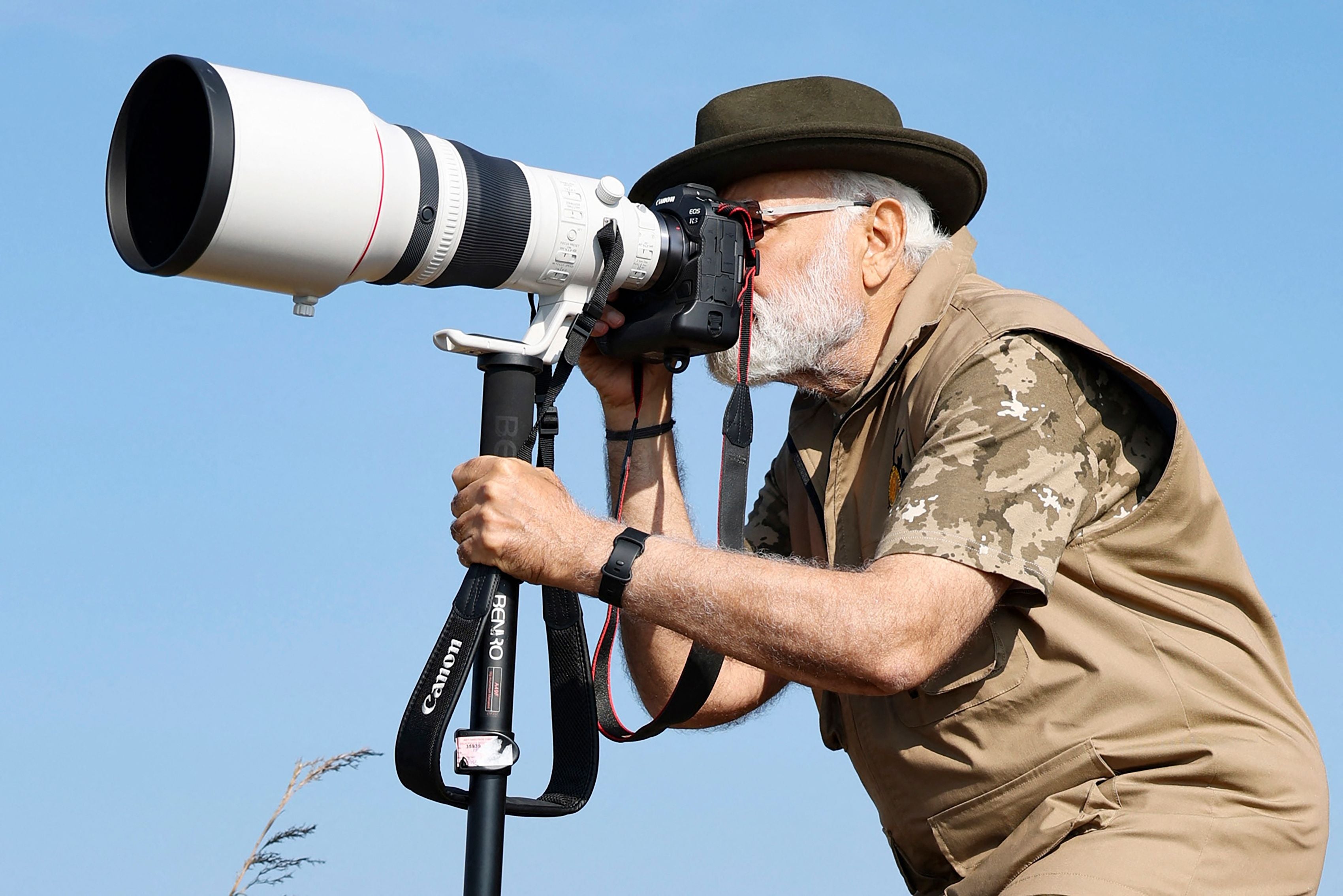 This handout photograph taken on 9 April 2023 and released by the Indian Press Information Bureau (PIB) shows India’s prime minister Narendra Modi taking photographs during his visit to the Bandipur and Mudumalai Tiger Reserves, in Karnataka state