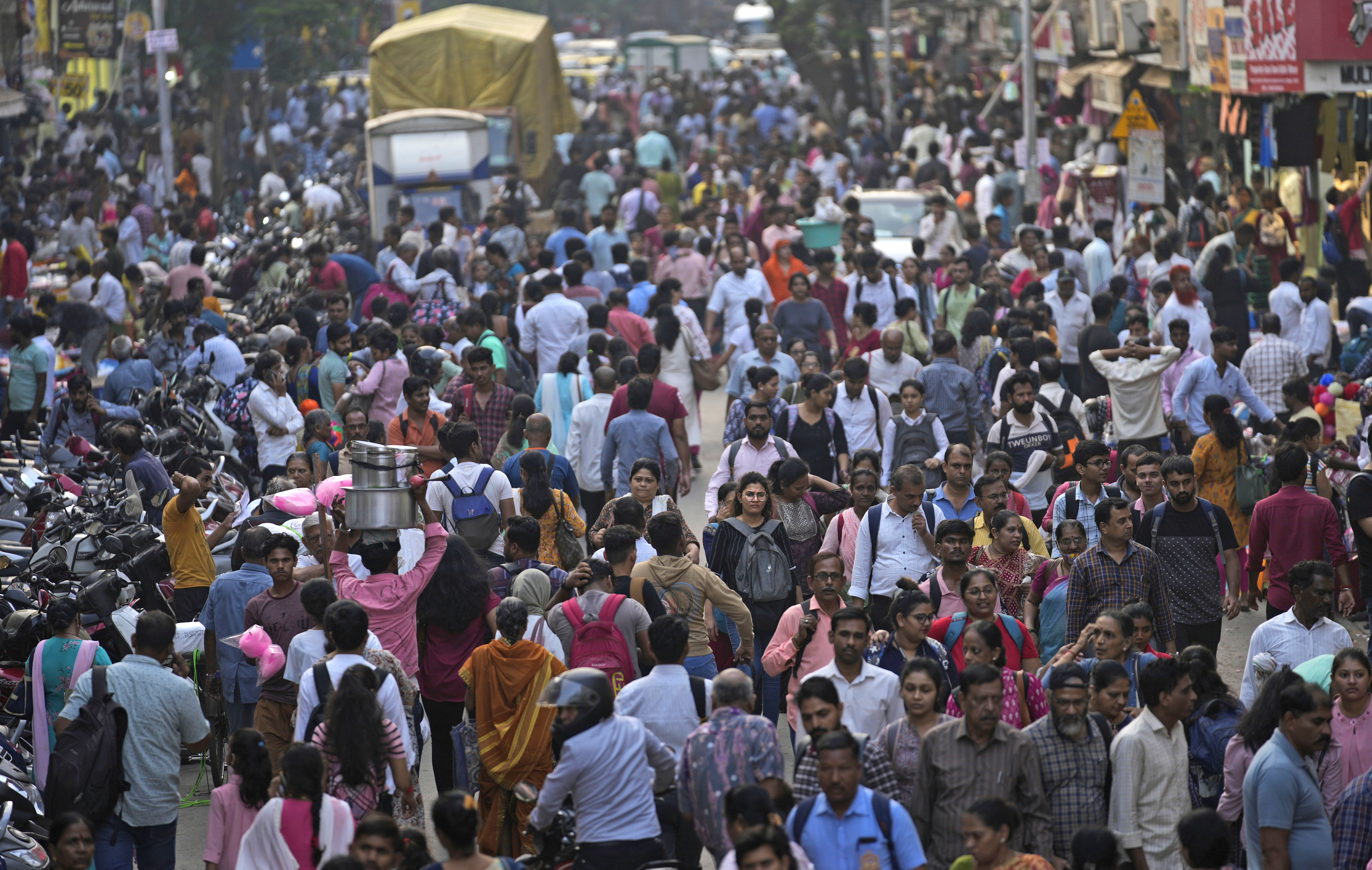 A crowd walks in a market area outside Dadar station in Mumbai, India, Friday, 17 March 2023