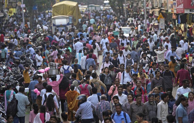 <p>A crowd walks in a market area outside Dadar station in Mumbai, India, Friday, 17 March 2023</p>