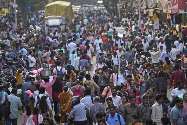 <p>A crowd walks in a market area outside Dadar station in Mumbai, India, Friday, 17 March 2023</p>