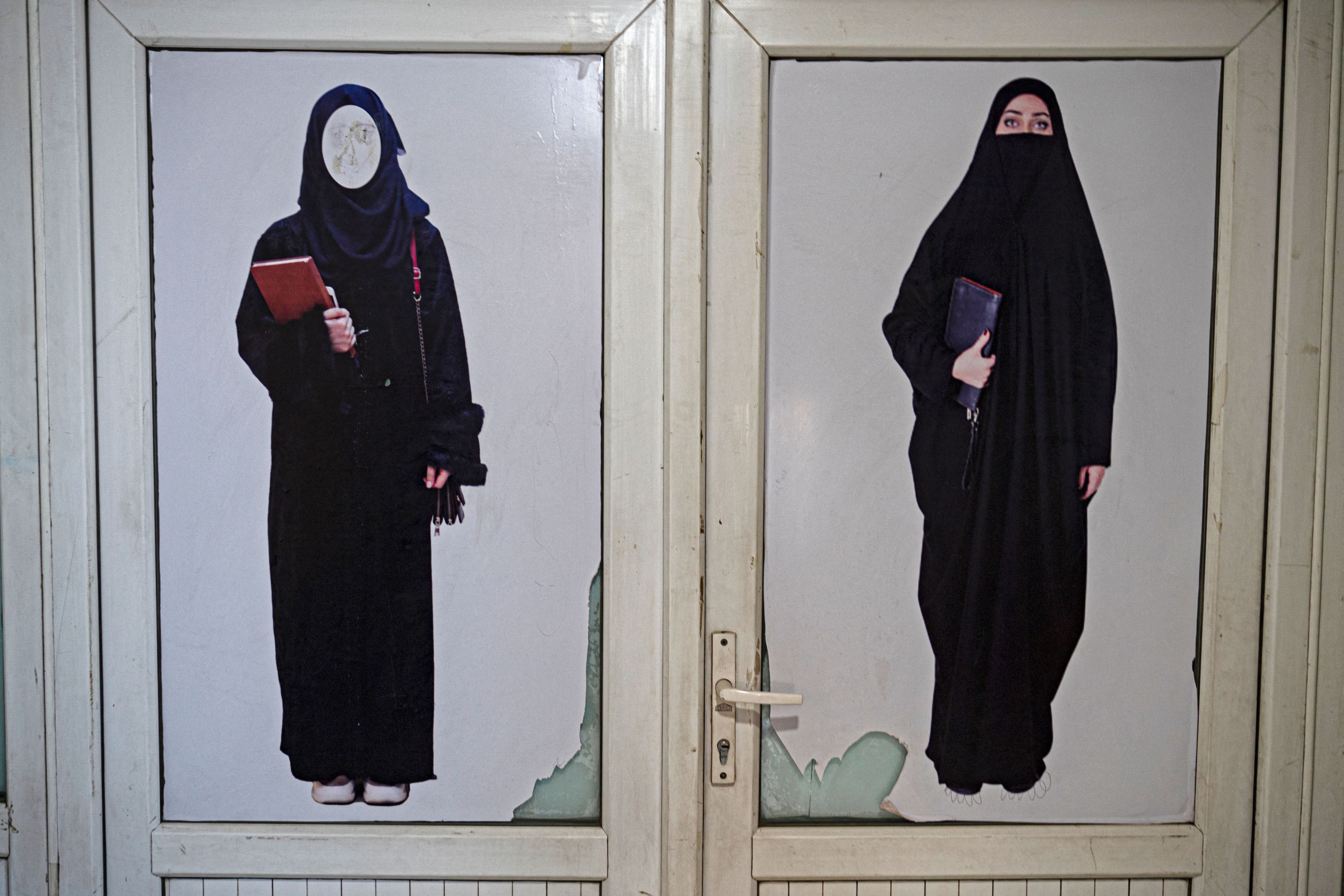 A poster pasted on a door ordering women to cover themselves with a hijab is pictured at a private university in Kabul