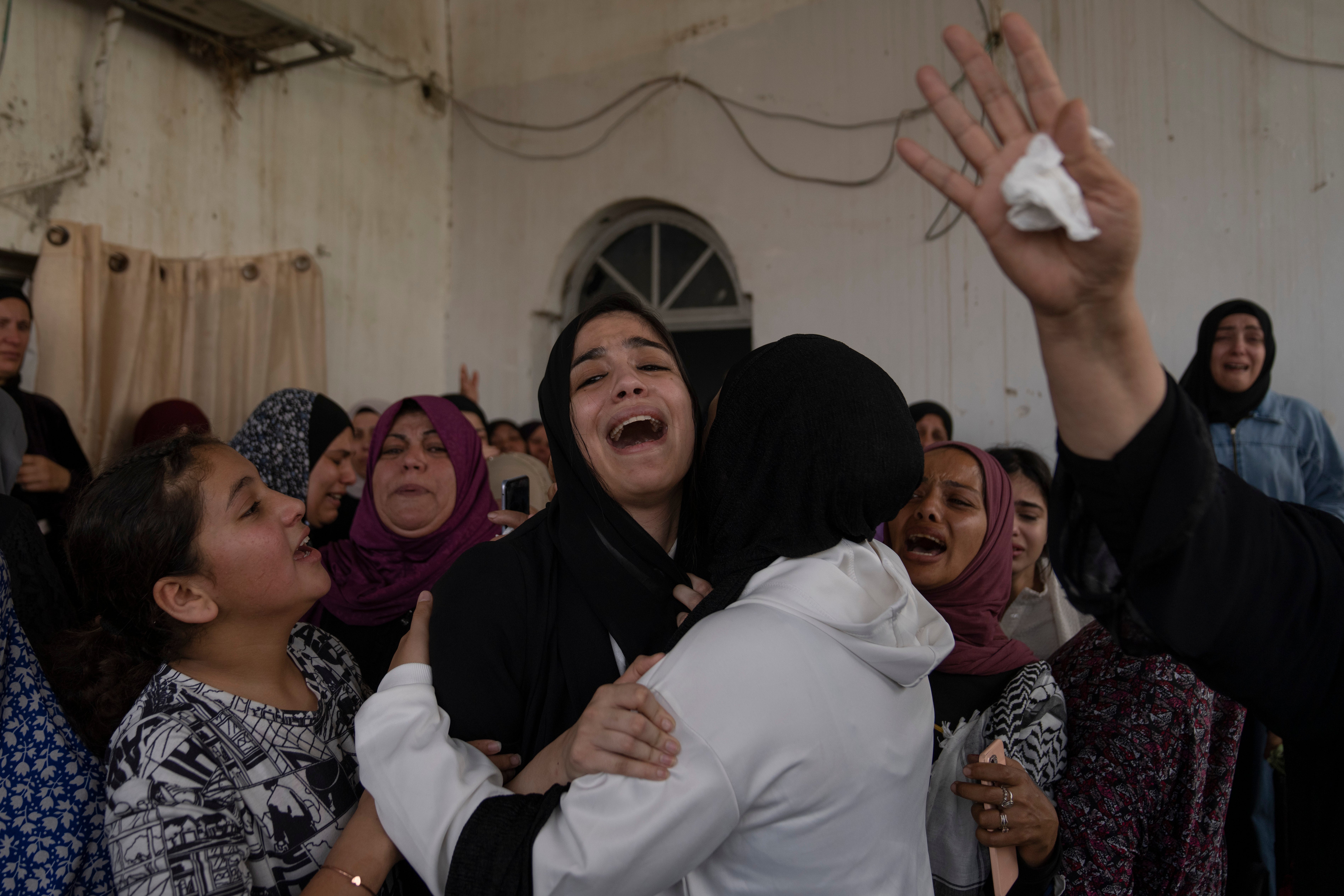 Palestinian mourners cry after taking the last look at the body of Mohammad Balhan during his funeral on Monday