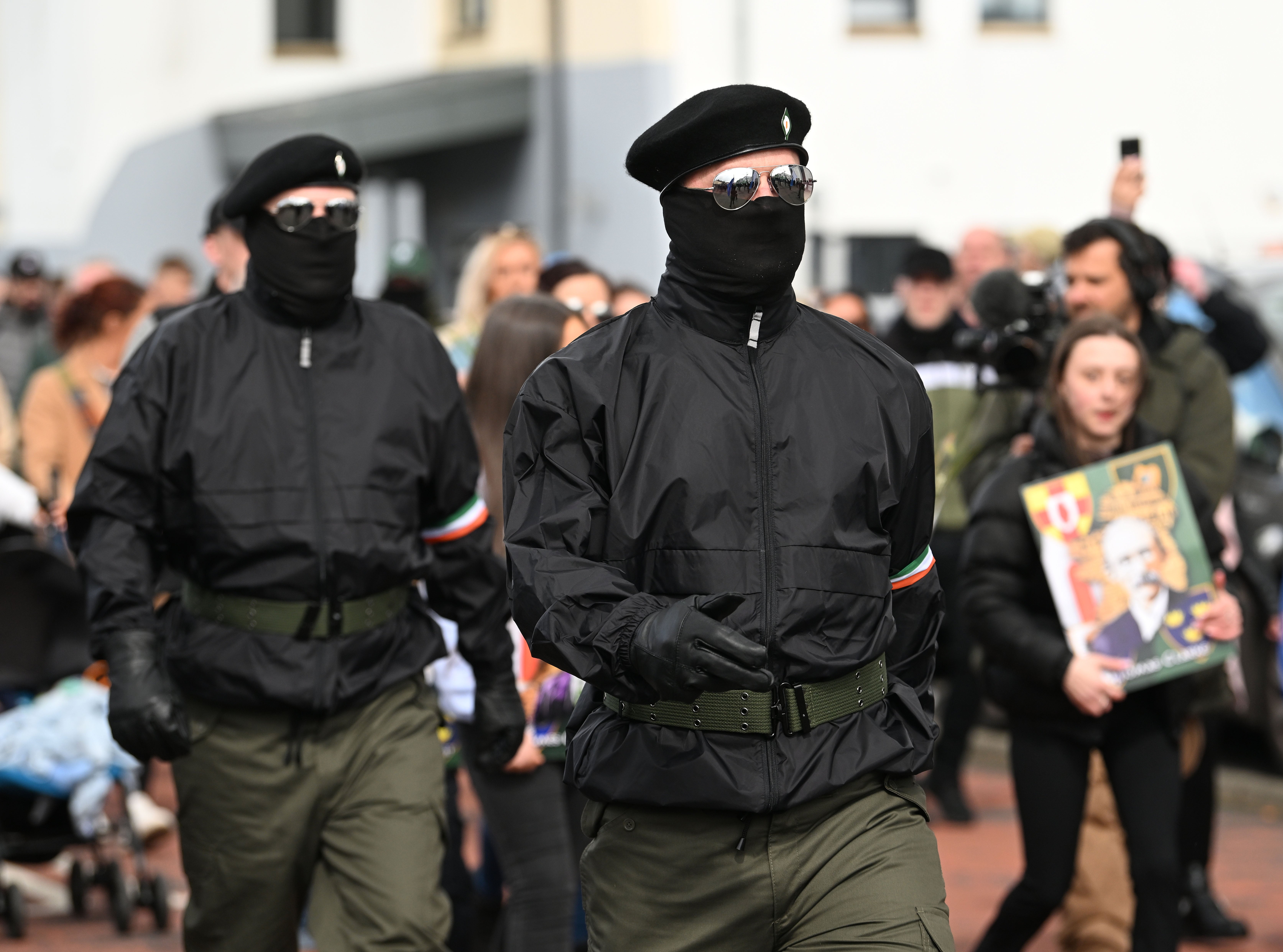 Masked men in paramilitary-style dress formed a colour party carrying the Irish flag and a host of republican flags