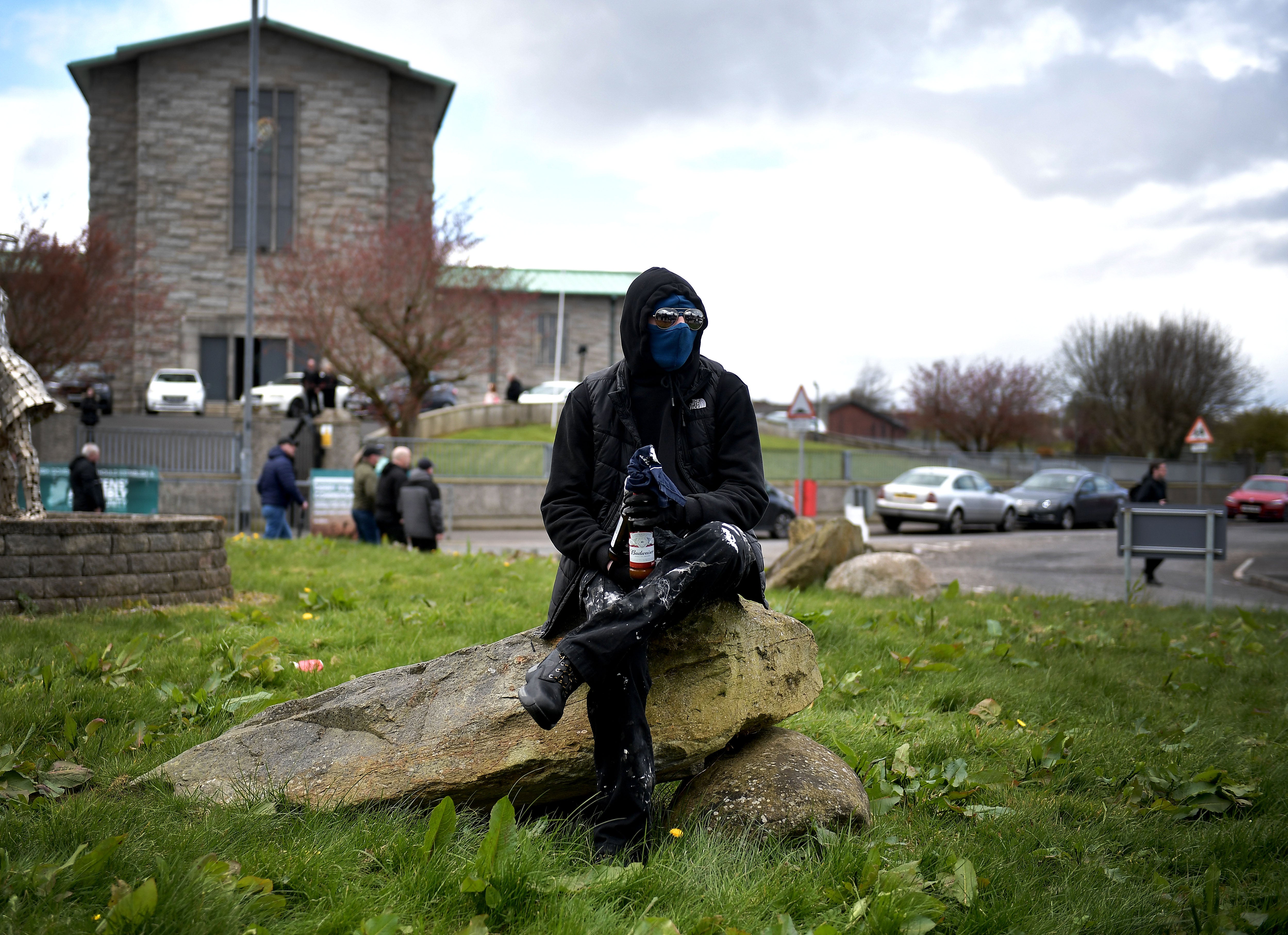 A dissident republican is seen with petrol bombs as a police vehicle is attacked