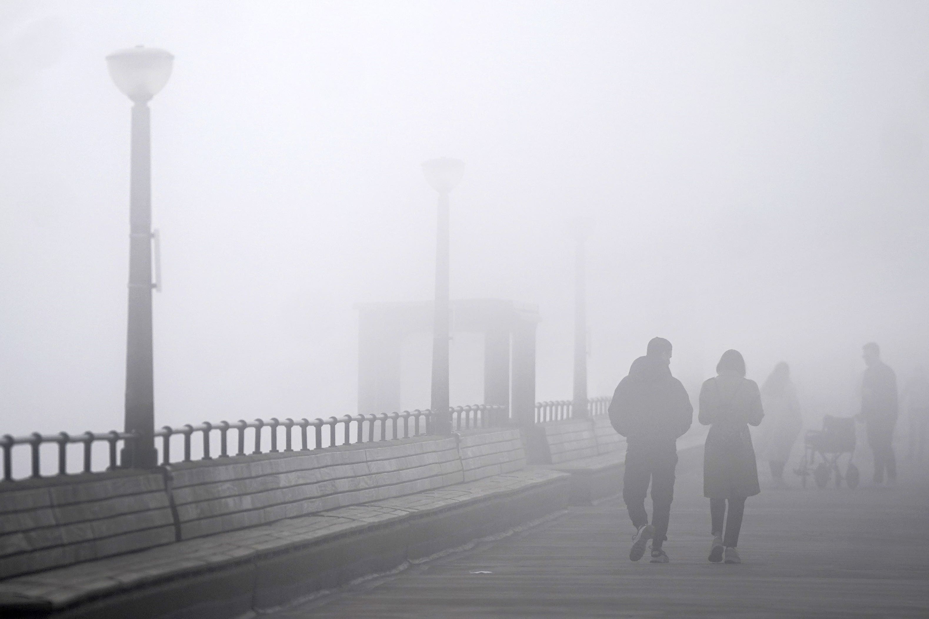 People walk through heavy mist on Deal Pier in Kent on Easter Monday (PA)