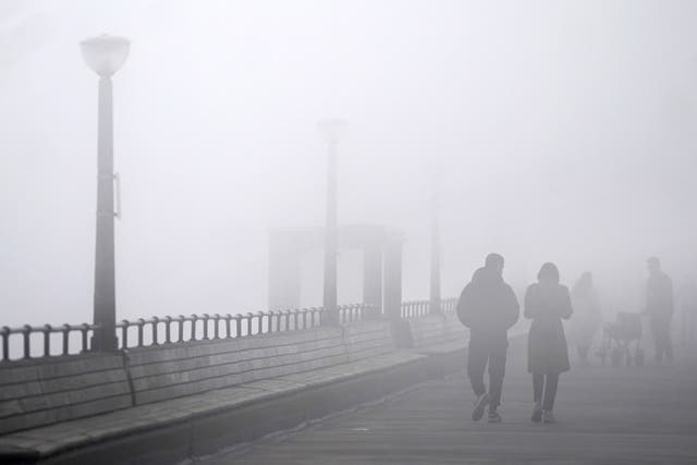 People walk through heavy mist on Deal Pier in Kent on Easter Monday (PA)