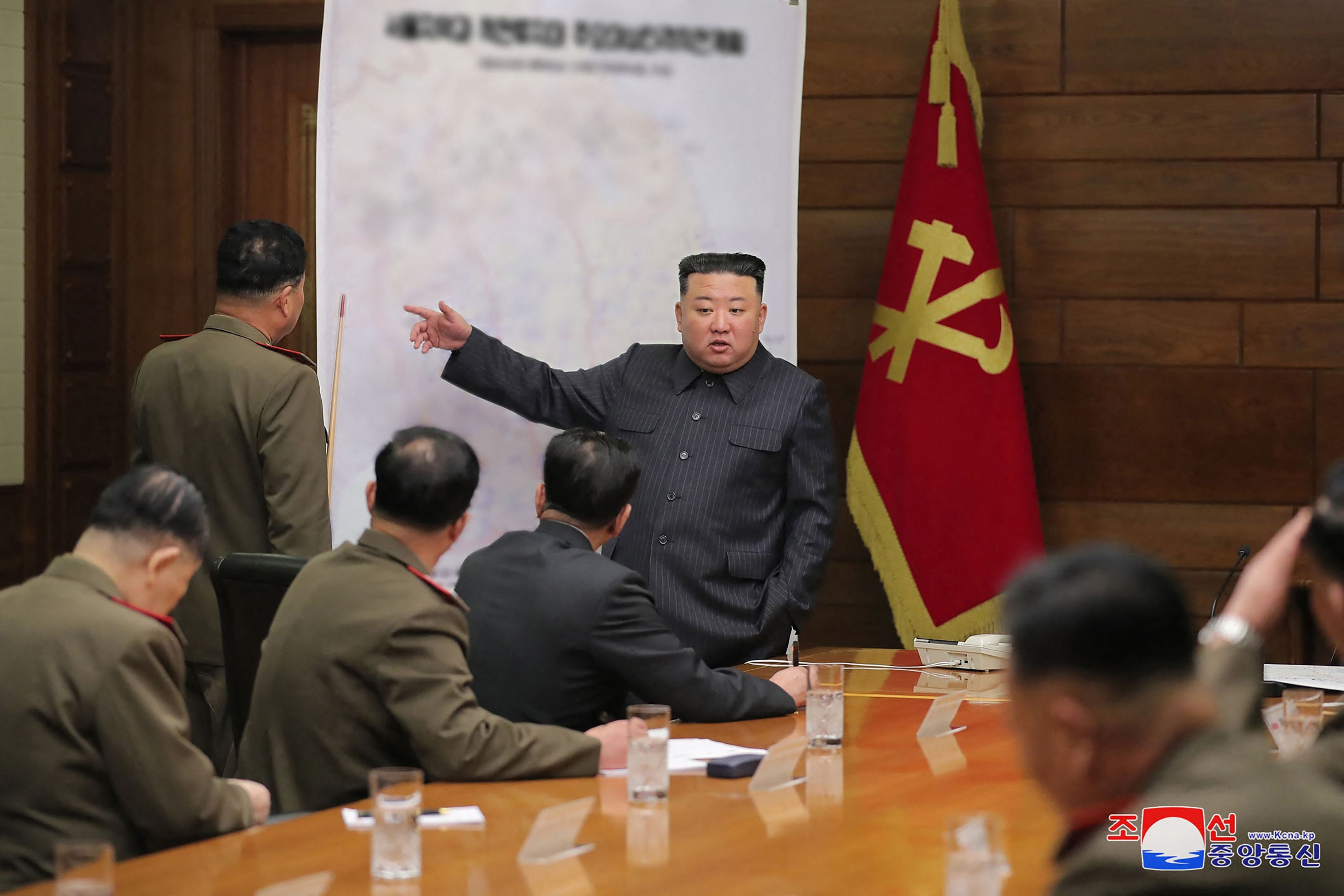 North Korean leader Kim Jong-un (C) gesturing in front of a map while attending the 6th Enlarged Meeting of the 8th Central Military Commission of the Workers' Party of Korea (WPK)