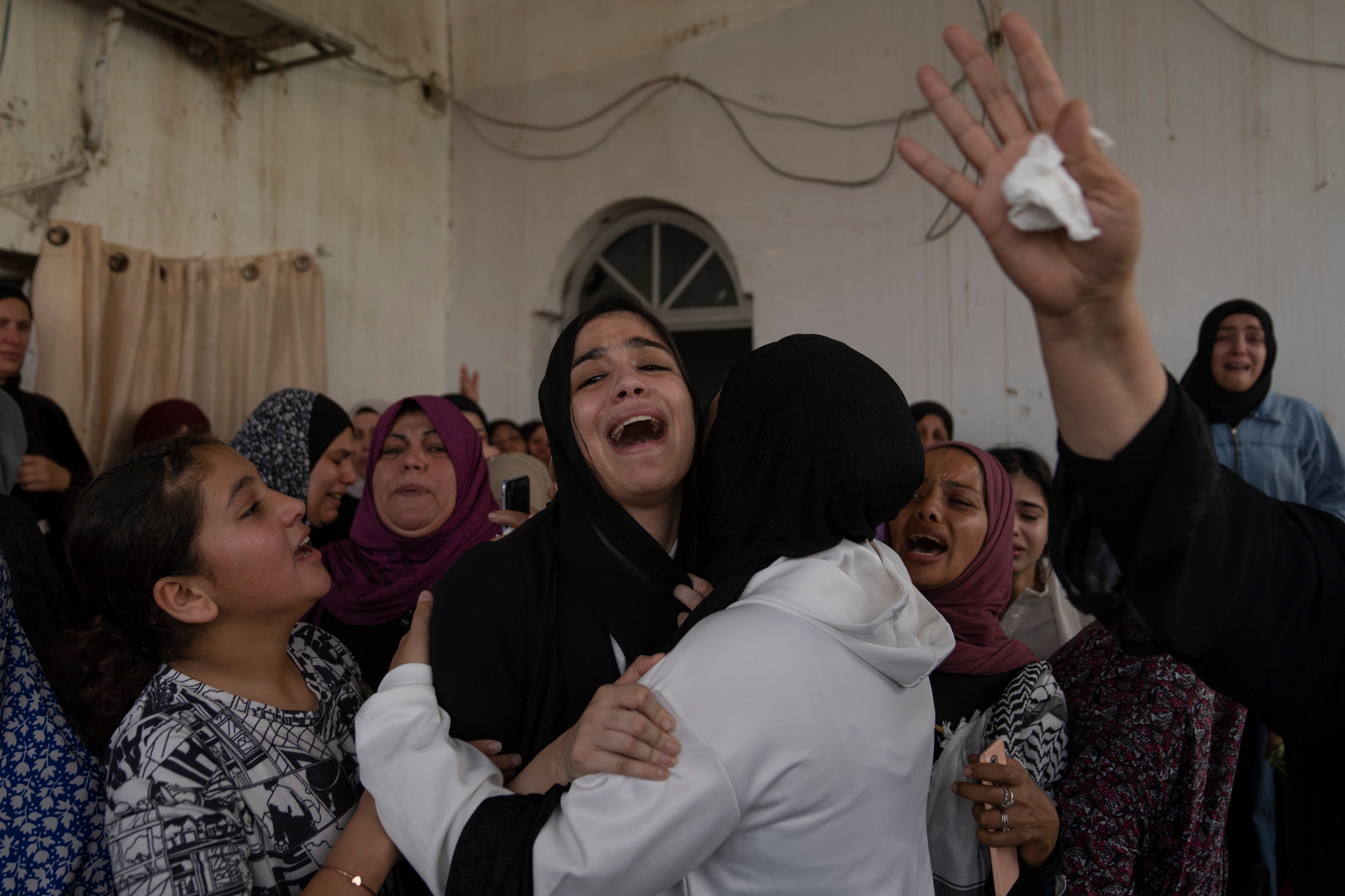 Palestinian mourners cry after taking the last look at the body of Mohammad Balhan, 15, during his funeral in the West Bank refugee camp of Aqabat Jaber, Jericho