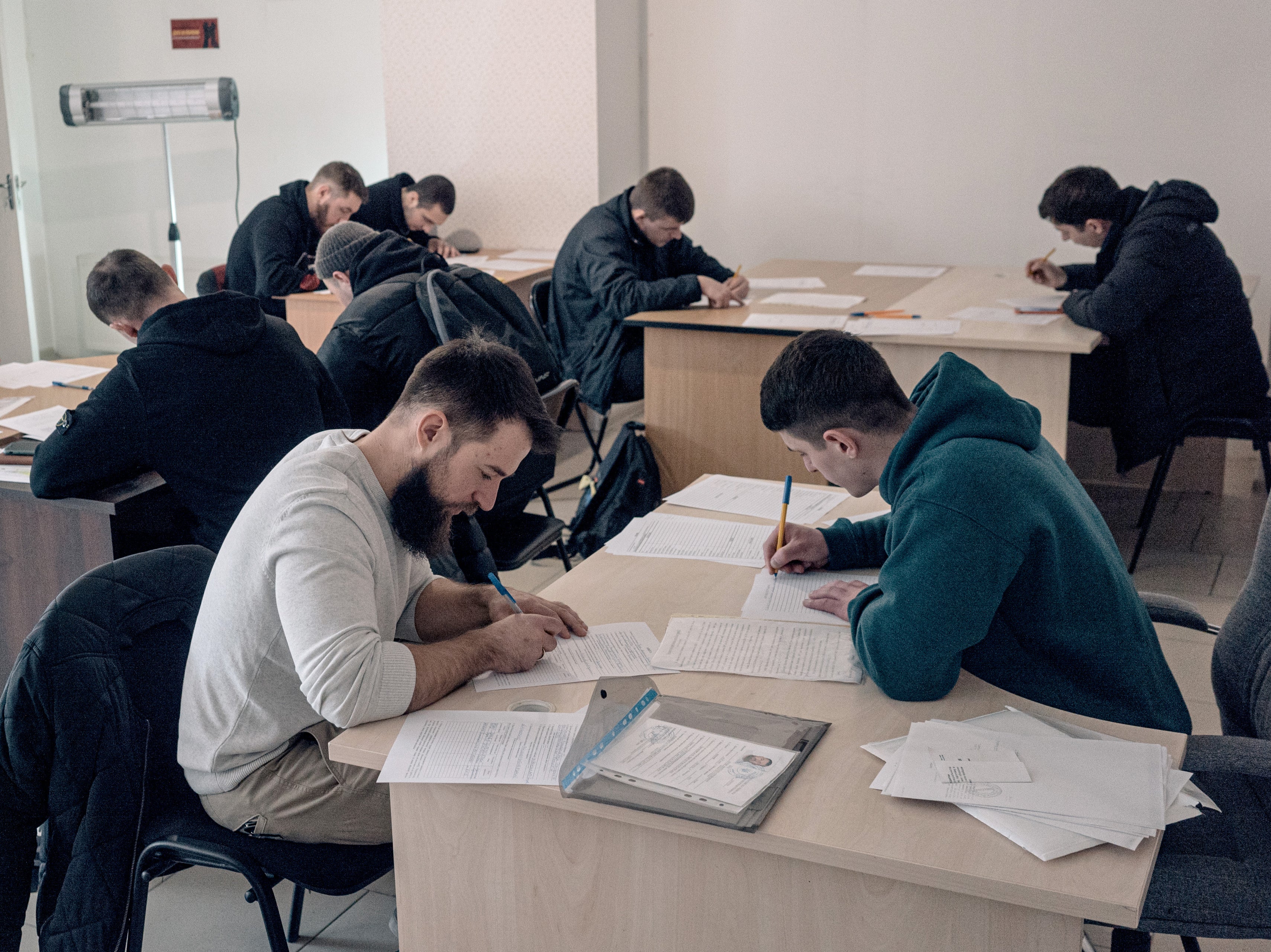 Volunteers fill out forms before being interviewed at an Azov Brigade recruitment centre