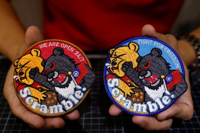 <p>Alec Hsu with the patches depicting a Formosan black bear holding Taiwan’s flag and punching Winnie-the-Pooh</p>