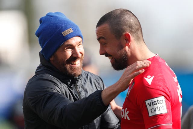 <p>Ryan Reynolds celebrates after the match with Wrexham’s Ollie Palmer</p>