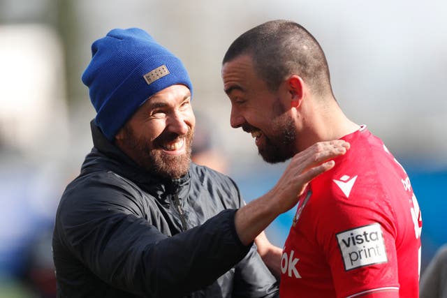 <p>Ryan Reynolds celebrates after the match with Wrexham’s Ollie Palmer</p>