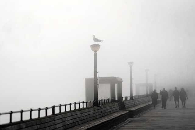 People walk through heavy mist on Deal Pier in Kent on Easter Monday, after a warm spell of weather earlier over the Easter weekend comes to an end. Picture date: Monday April 10, 2023.