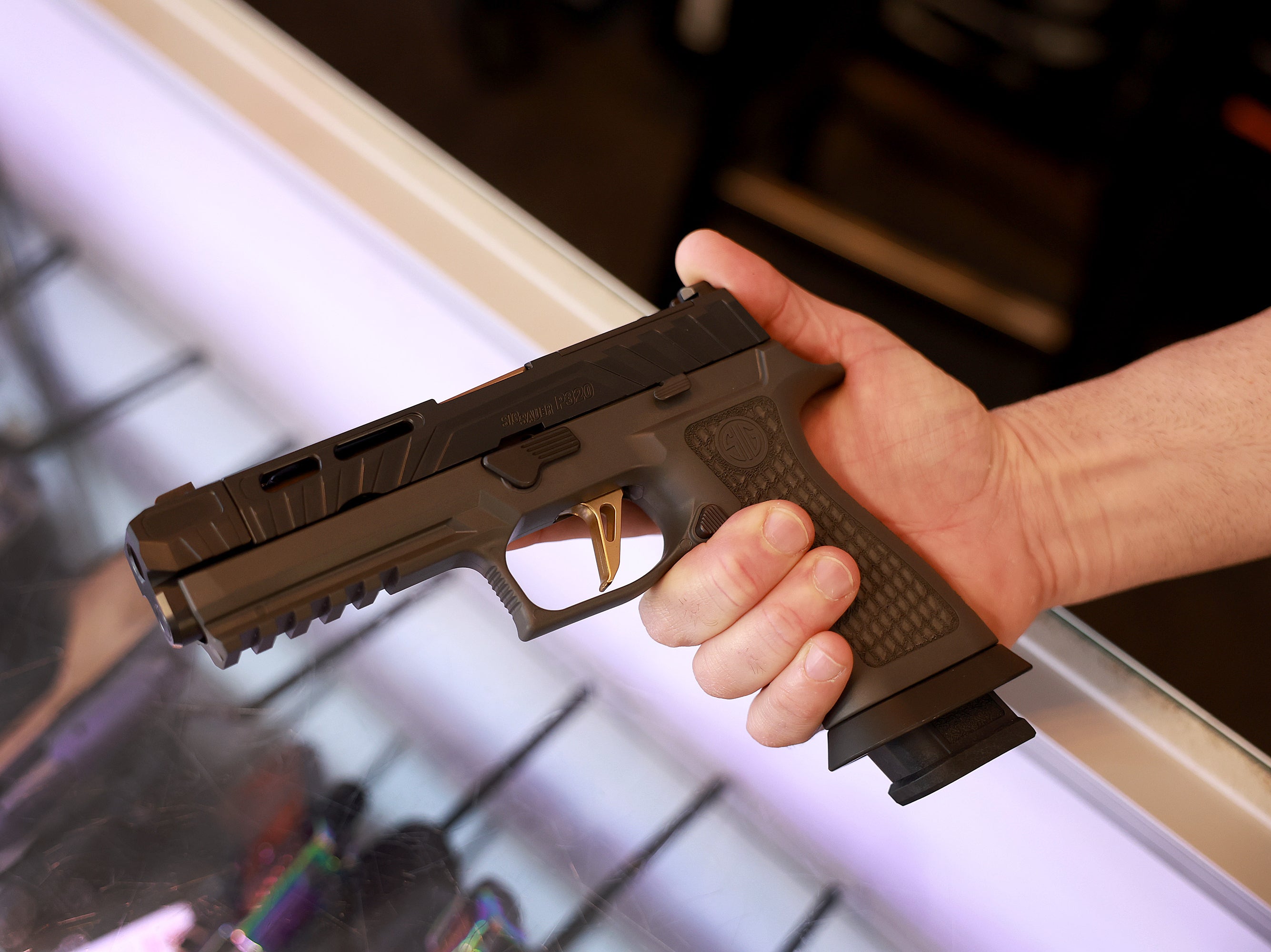 A Sig Sauer P320 handgun is held at the WEX Gunworks store in Delray Beach, Florida